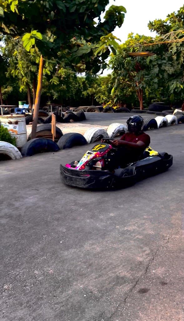 Rayann driving a go-kart on an outdoor track.